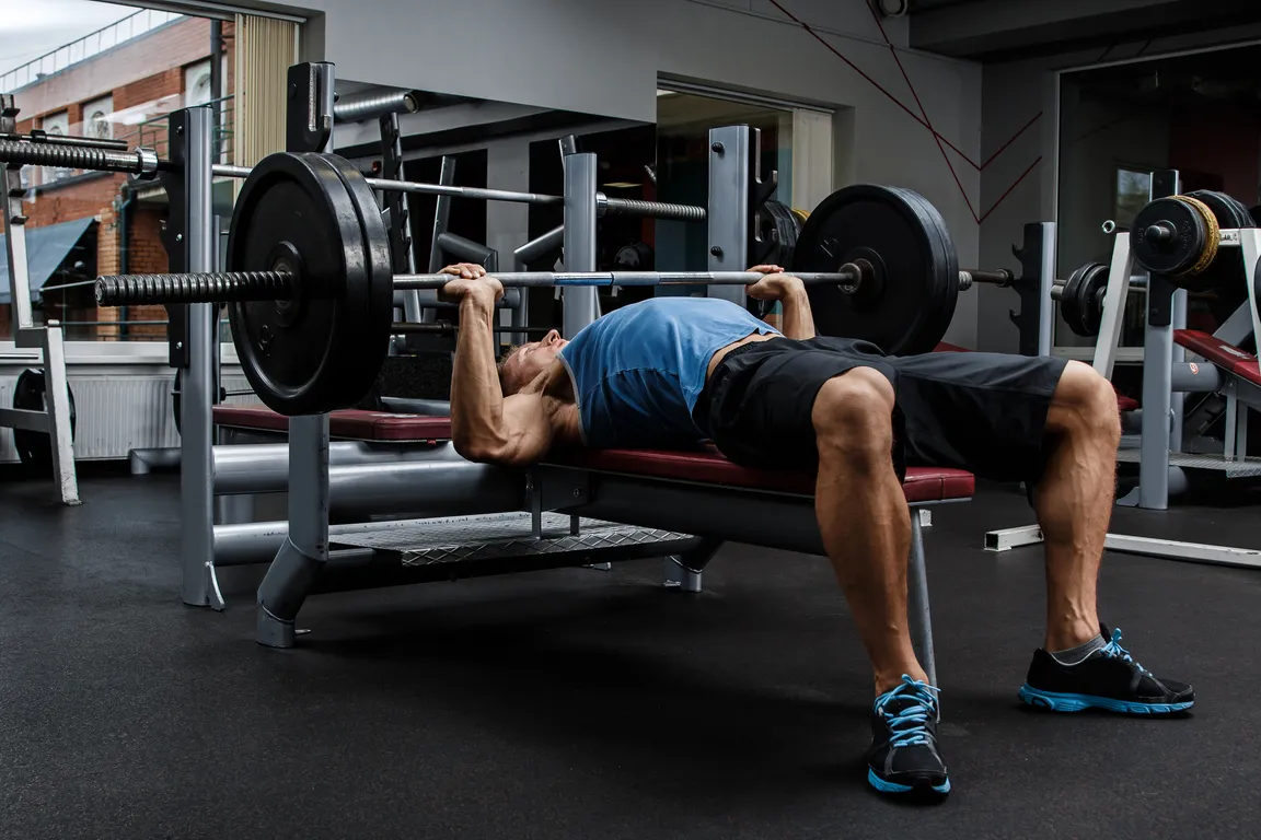 Man benchpressing in gym